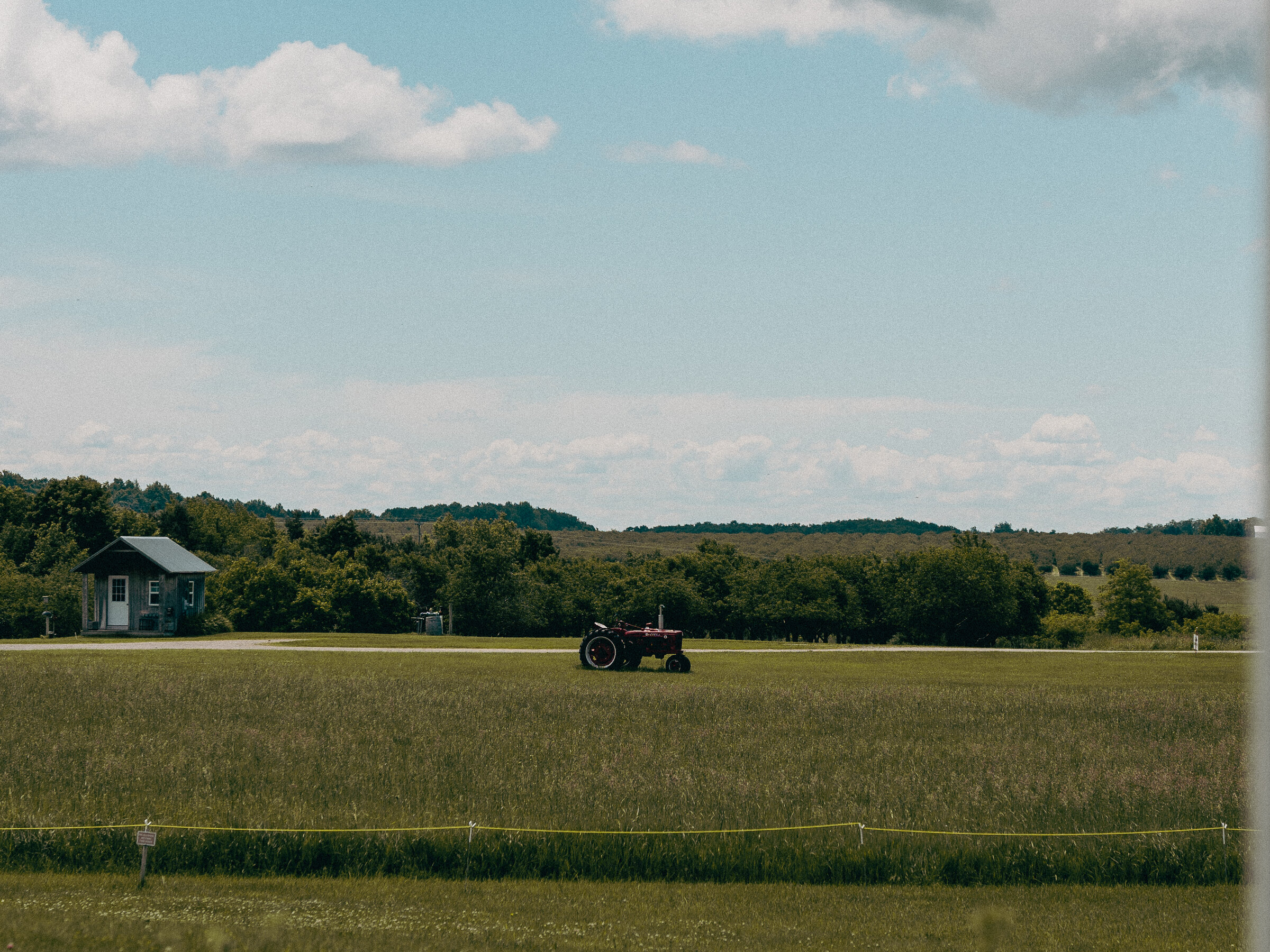 A vintage tractor crossing a wide Michigan field